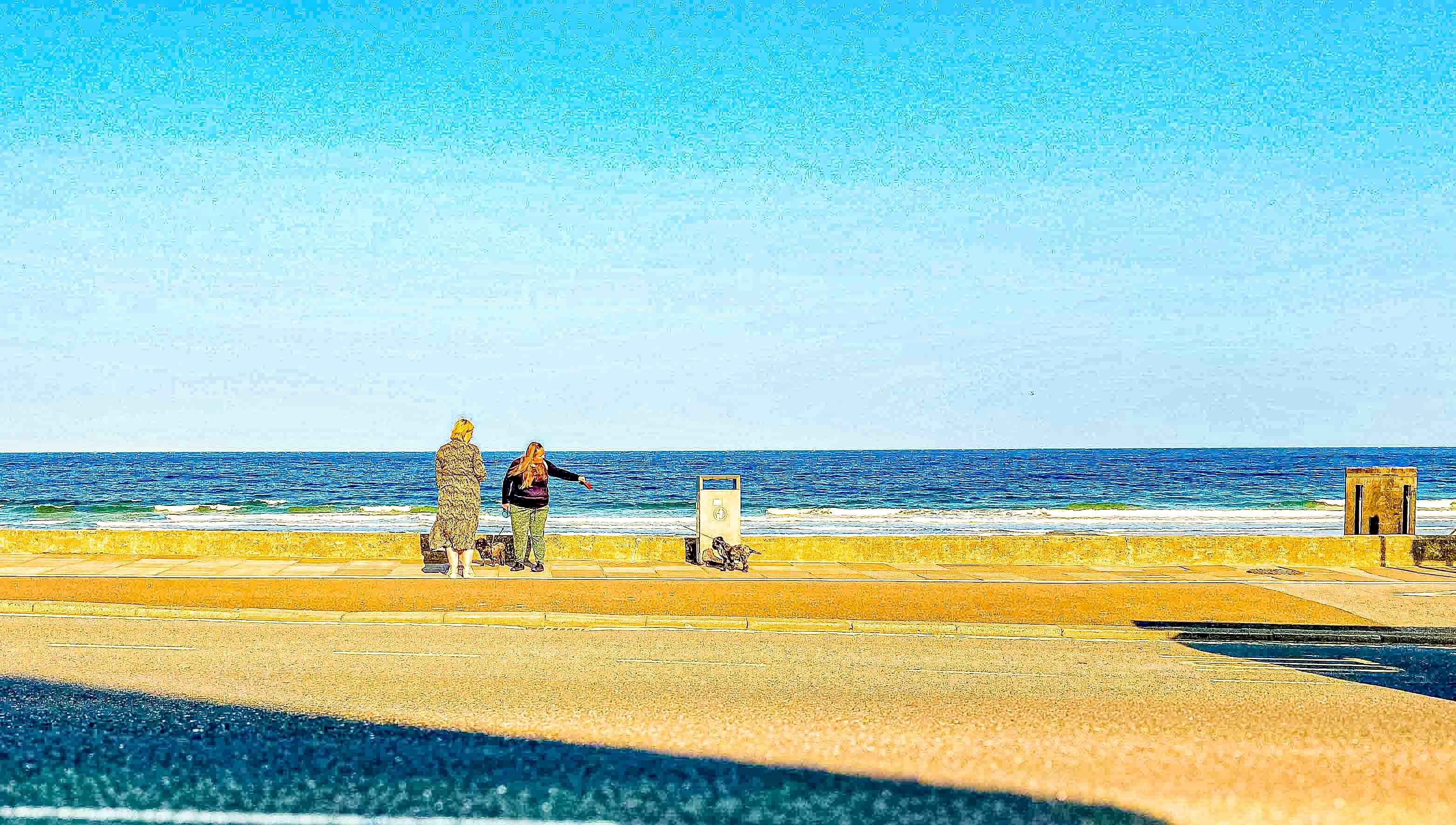 Beach 26 — two figures on the promenade wall